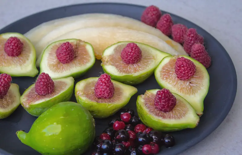 assiette de fruits d'été : melon, figues, fruits rouges