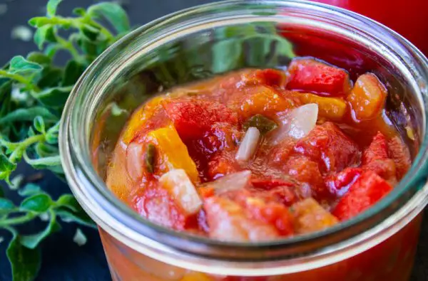 Petit pot de compotée de tomates aux poivrons avec de l'origan